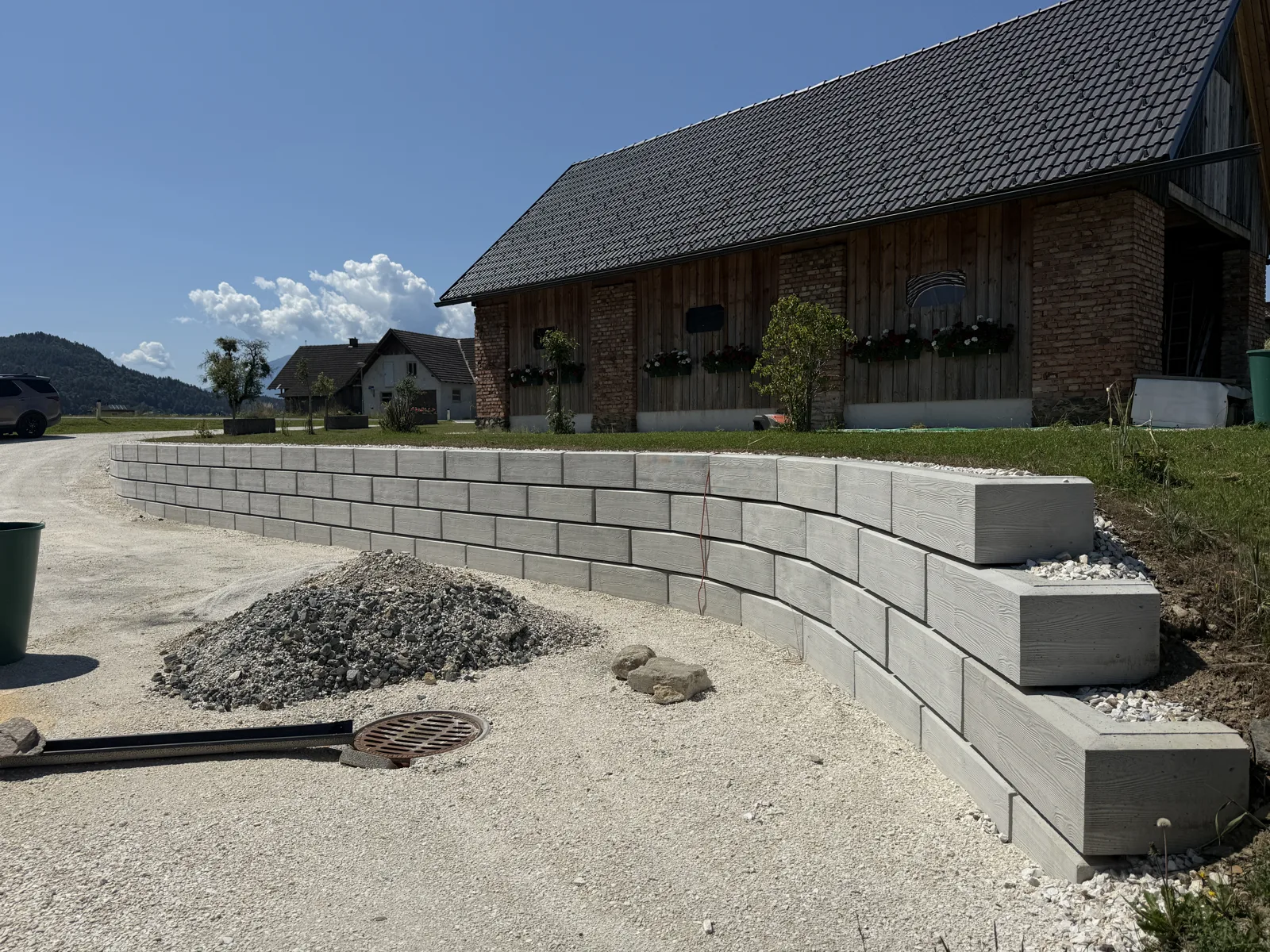 Stützwand aus ZEMROCK Betonfertigteilen fängt den seitlichen Höhenunterschied an einer Einfahrt ab