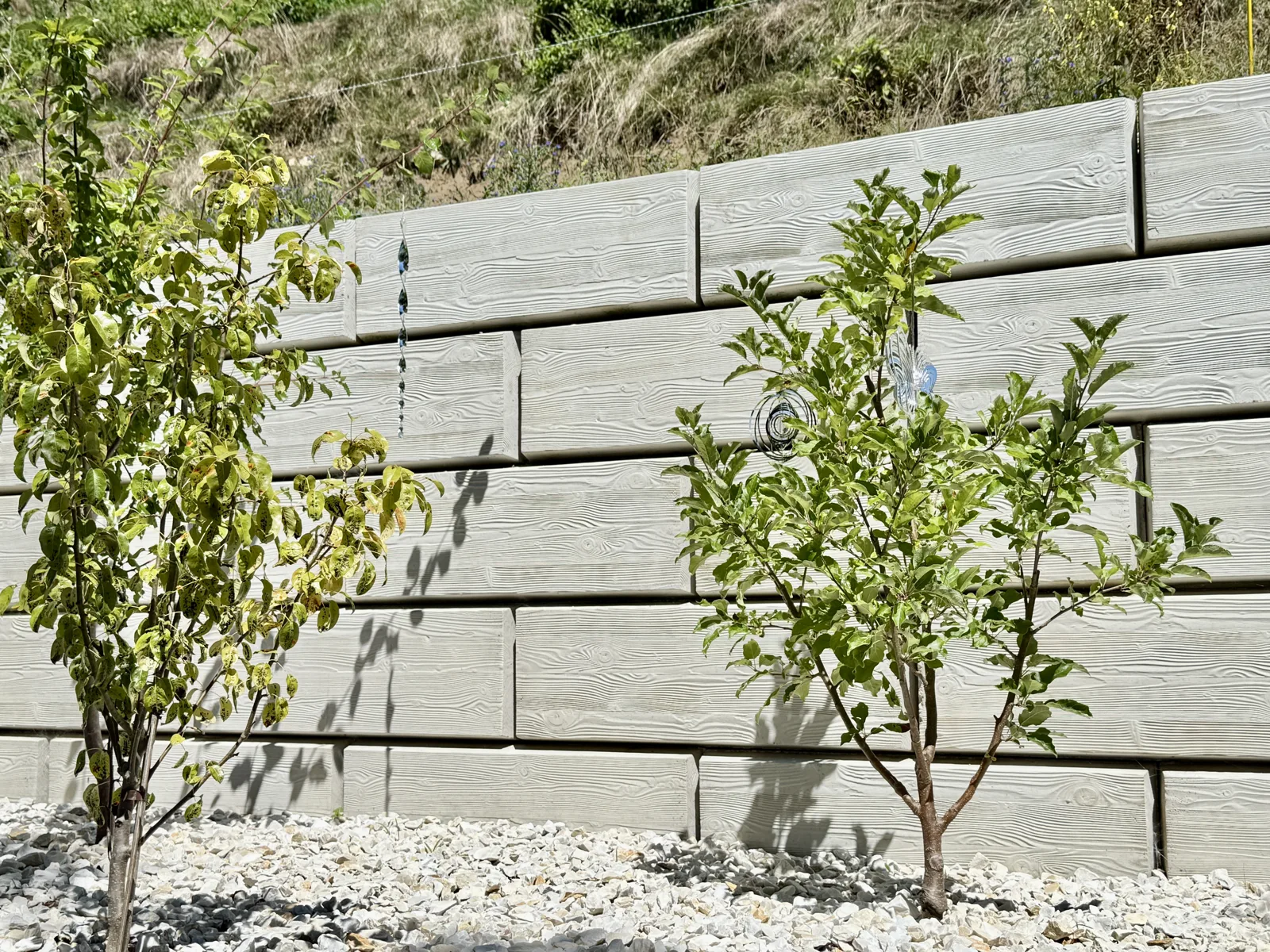 Stützwand aus ZEMROCK Betonfertigteilen in einem Garten in Griffen