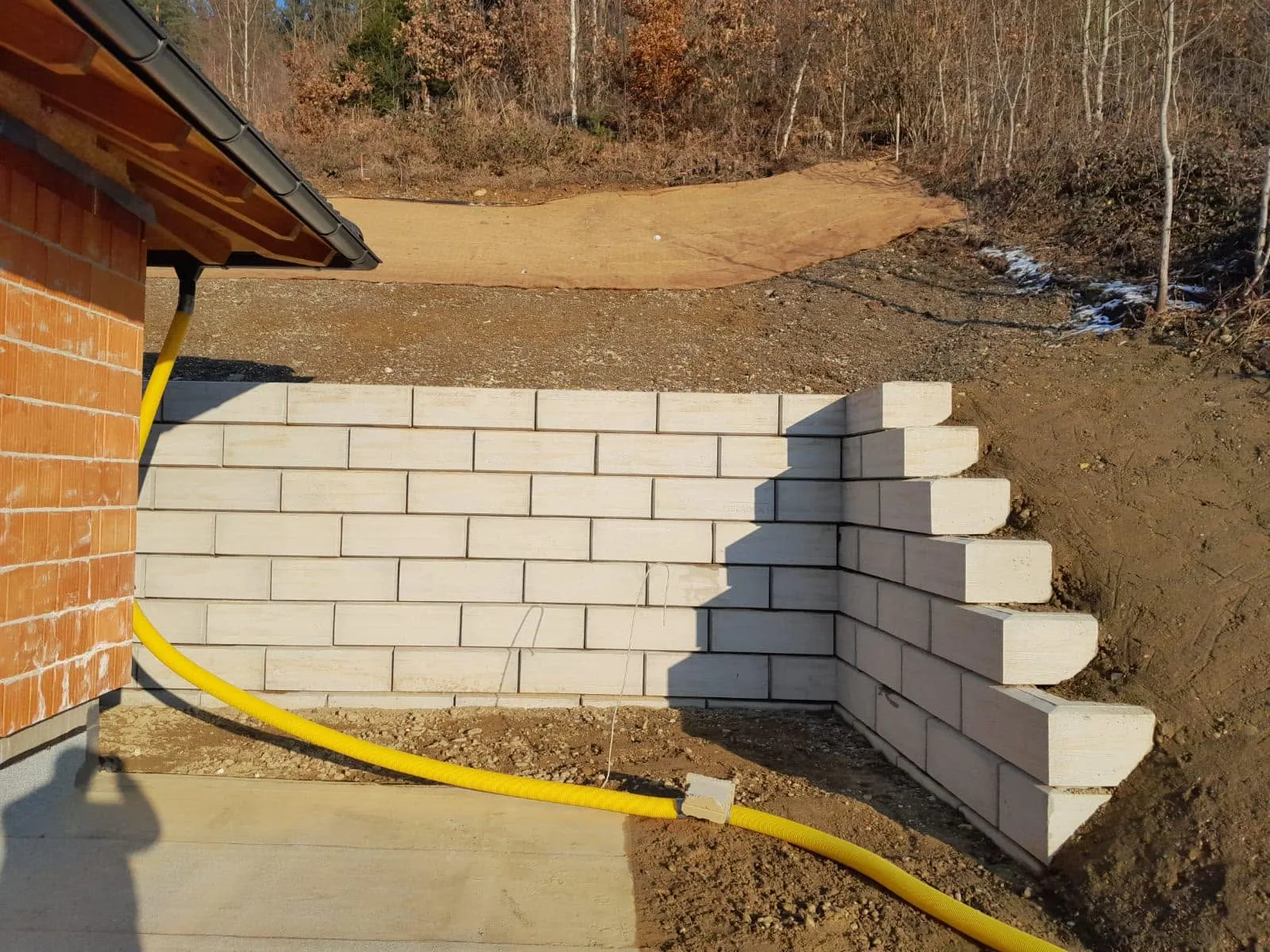 Stützwand aus ZEMROCK Betonfertigteilen zur Geländesicherung nach dem Rohbau