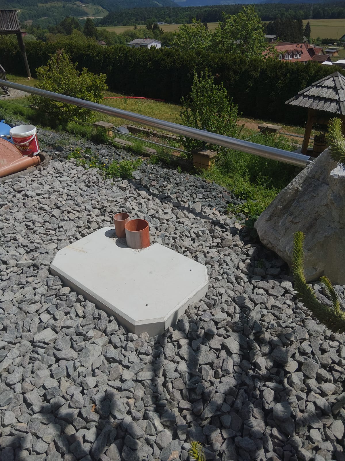 Fertig aufgestelltes ZEMROCK-Betonfundament für eine Wärmepumpe im Kiesbeet